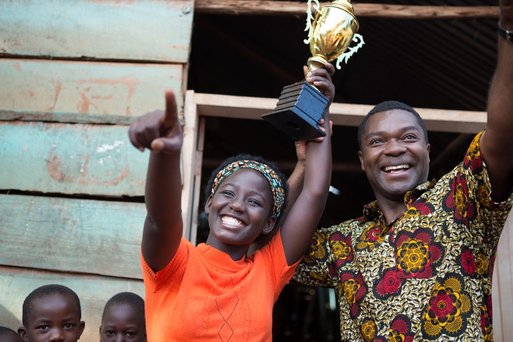 David Oyelowo is Robert Katende and Madina Nalwanga is Phiona Mutesi in in Disney's QUEEN OF KATWE, based on a true story of a young girl from the streets of rural Uganda whose world rapidly changes when she is introduced to the game of chess. Oscar (TM) winner Lupita Nyong'o also stars in the film, directed by Mira Nair.